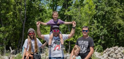 A joyful family enjoying a sunny day outdoors, captured in a lively and happy moment.