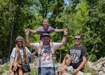 A joyful family enjoying a sunny day outdoors, captured in a lively and happy moment.